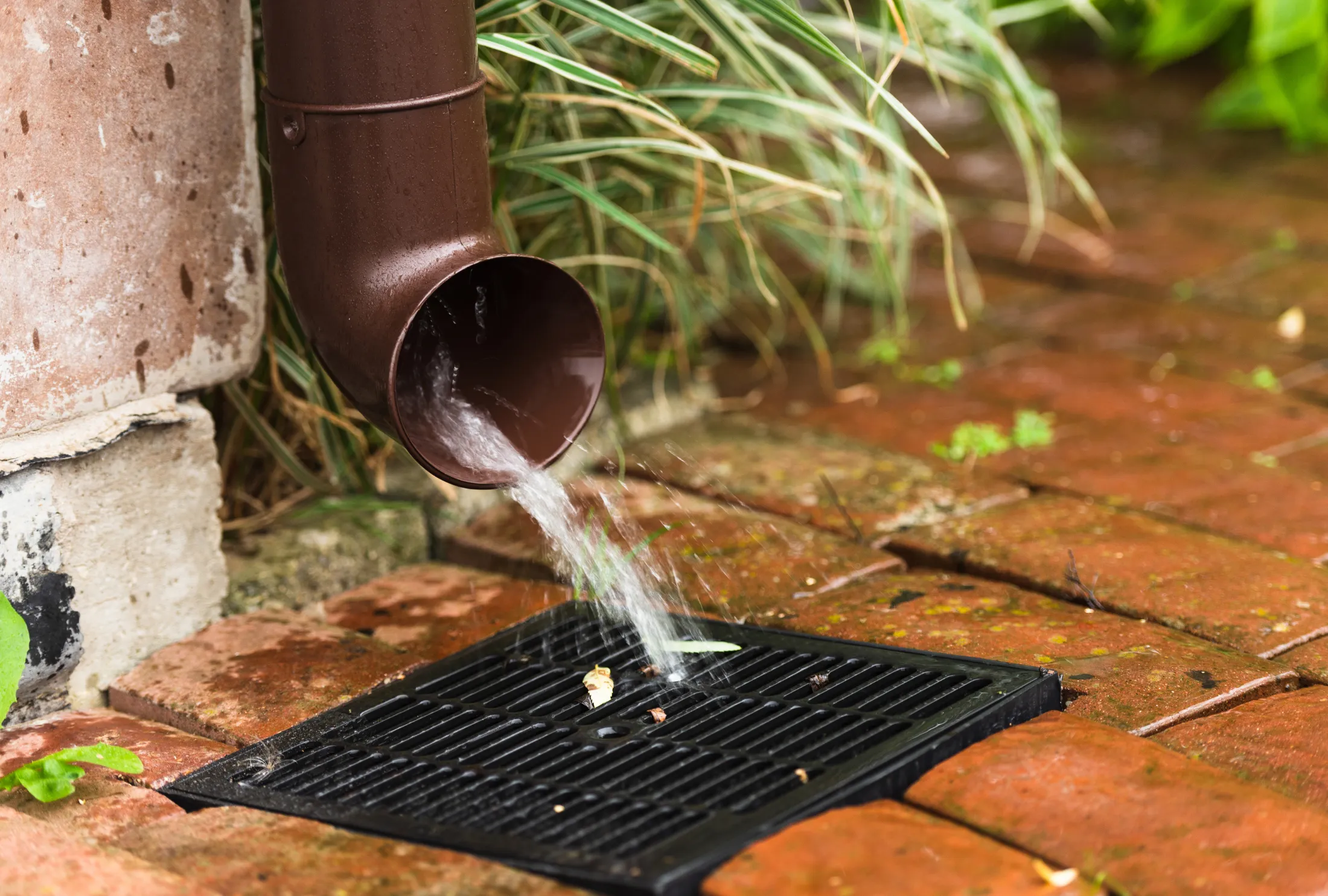 clearing drain pipe as part of outdoor drainage maintenance